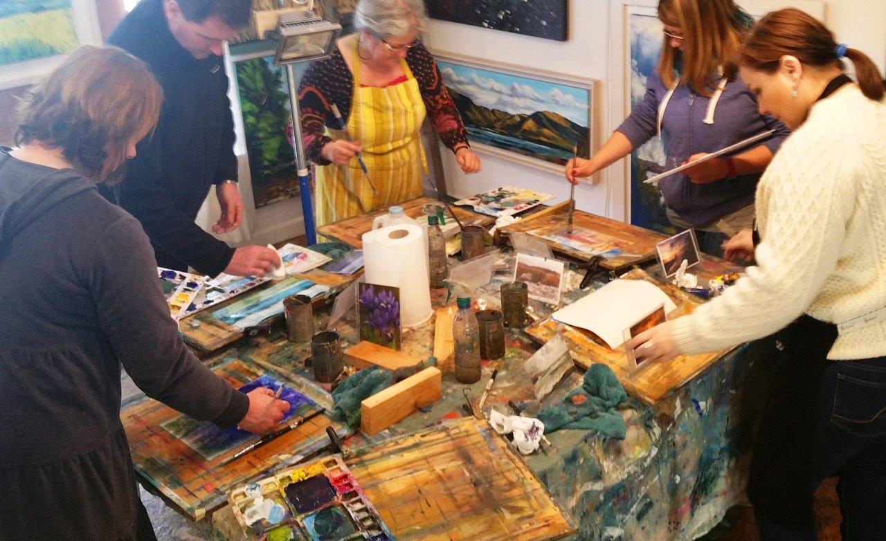 Five painting students working at one big table.