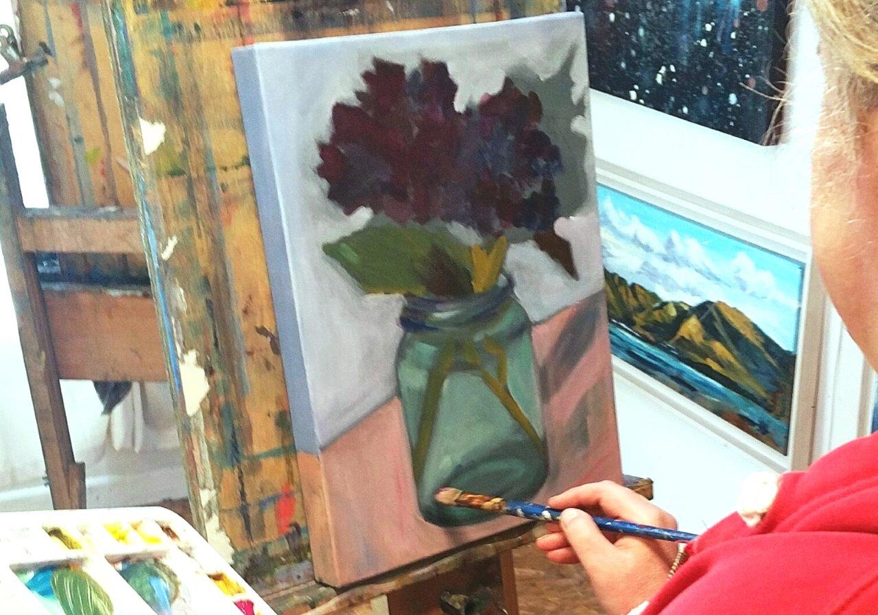 Art student paints flower in a jar with delicate colours. November Painting Course.