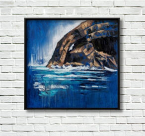 Skellig Arch canvas print displayed in a black frame on a white brick wall.