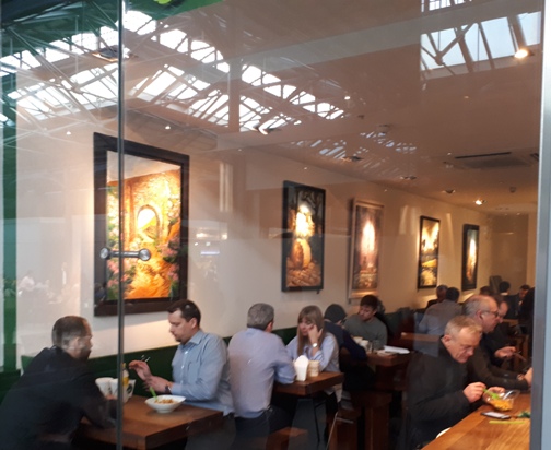 Photo shows Diners at Tossed Noodles enjoy lunch surrounded by Rod Coyne's art.