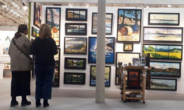  Rod Coyne's stand at 2018 Art Source be apprised by two keen fans.