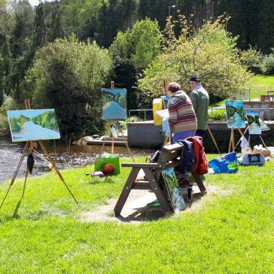 Photo of students working in the sunshine on the banks of the Avoca River during our August Painting Workshop in 2019.